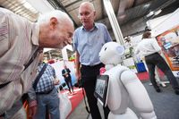 Besucher der Messe mit dem Roboter Pepper